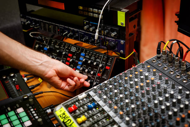 istock Hand of a sound engineer on sound console mixer. Equalizer control. 1408058718
