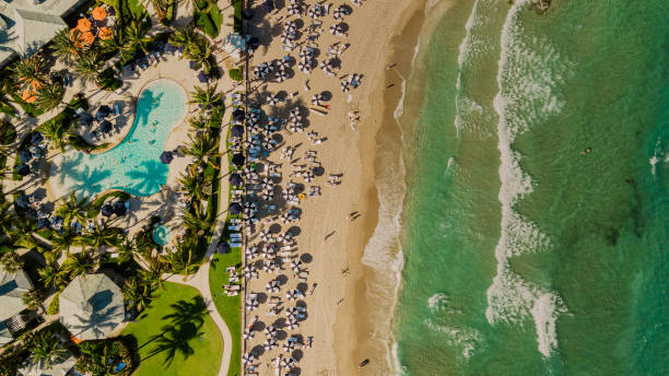 Aerial Drone View Directly Above a Beach Filled with Blue Beach Umbrella on the Sandy Shoreline in Palm Beach, Florida at Midday During the Spring of 2022 Aerial Drone View Directly Above a Beach Filled with Blue Beach Umbrella on the Sandy Shoreline in Palm Beach, Florida at Midday During the Spring of 2022 west palm beach stock pictures, royalty-free photos & images