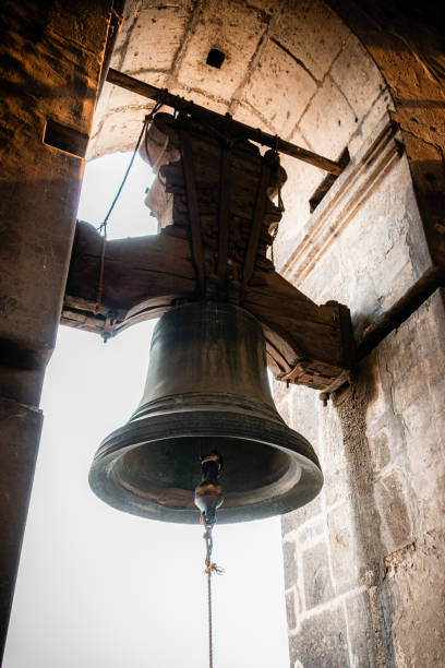High contrast backlit vertical photograph of one of the bells of the Mexico City Metropolitan Cathedral located in Mexico City; the bell was cast in 1578 and bore the name fotografía retroiluminada de alto contraste bajo y ángulo en formato vertical de una de las campanas fundidas en cobre, bronce y estaño en 1578 y su poste atado a una cuerda colgada en la catedral metropolitana de la ciudad de méxico en la capital de m