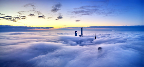 Drone point view of Shanghai landmark building on thick cloud at dawn, China.