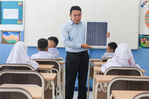 istock Schoolchildren with teacher studying solar panels in class 1408063835