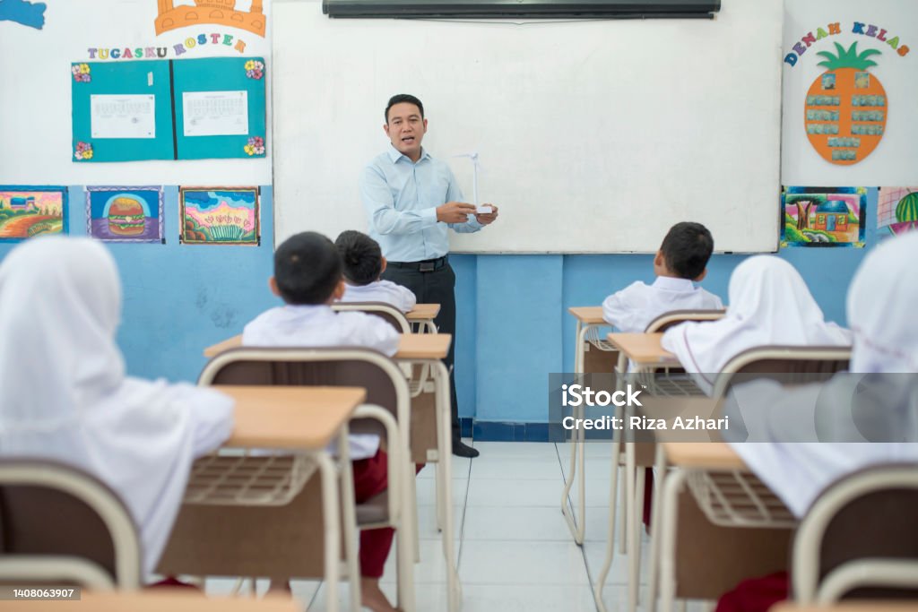 Teacher teaching concepts of windmill in the classroom to students Indonesia Stock Photo