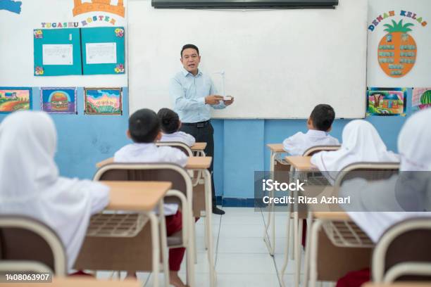 Teacher Teaching Concepts Of Windmill In The Classroom To Students Stock Photo - Download Image Now