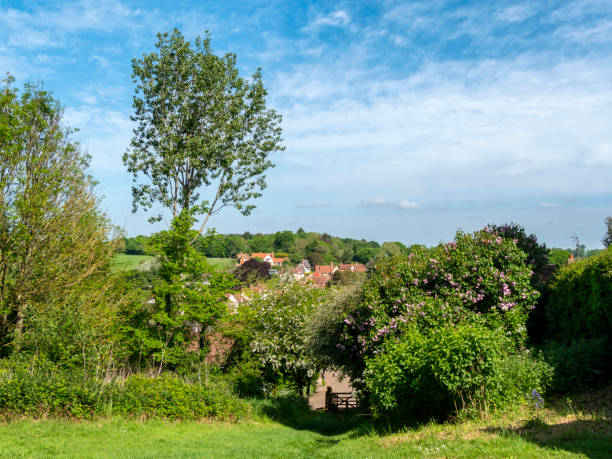 The rooftops of the lovely village of Kersey in Suffolk, Eastern England, seen from the graveyard of St Mary’s church. The village, which gave its name to a type of cloth, has a long, picturesque street of beautiful timber-framed medieval houses and a ford across a stream known locally as “The Splash”; it is exceptionally popular with tourists and film companies.