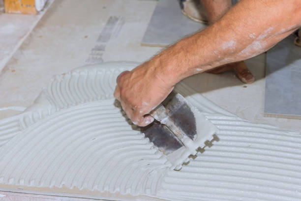 istock Spreading wet mortar before applying tiles to the bathroom floor puts adhesive 1408068012