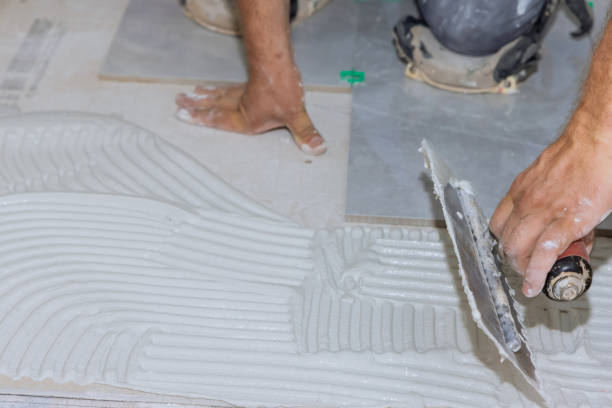 istock Adding wet mortar to the bathroom floor before applying tiles puts adhesive on the tiles 1408068023