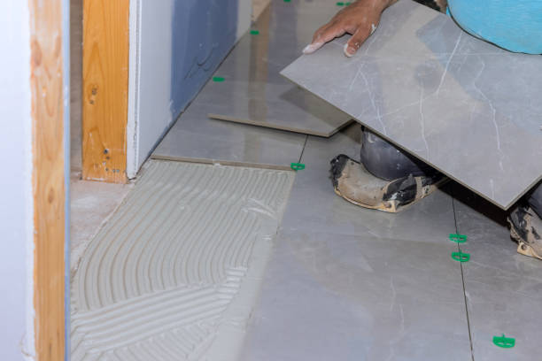 istock Working on a home construction project laying ceramic floor tiles on an adhesive surface 1408068055