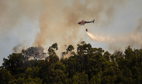 Firefighter Helicopter fighting against a Forest Fire during Day in Povoa de Lanhoso, Portugal.