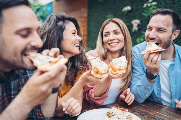 istock Group of friends eating pizza together 1408069942
