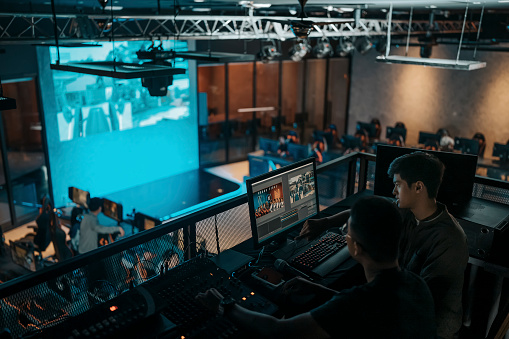 asian sports event crew working at backstage with control panel on stage lighting , sound system and lighting effect