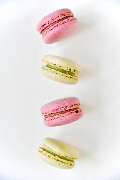 istock Falling macaroons on a white background. Sweet French desserts. Macaroons on a white plate. Macaroons on the table in the afternoon. 1408071020
