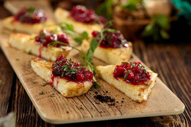 istock Hot appetizer for wine - grilled halloumi cheese with jam. Cheese appetizer baked halloumi on wooden background on rustic style. Adyghe cheese with berries dip on wooden table. 1408071513