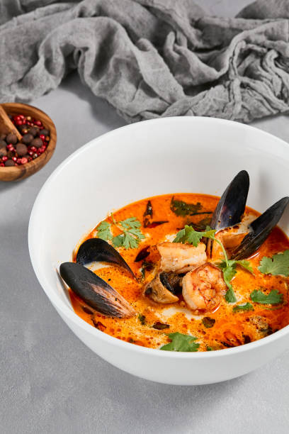 traditional asian food - tom yam kung with prawn and mussels. tom yum soup with seafood and coconut milk. tom yam in ceramic bowl on gray stone background. oriental cuisine. asian menu. - sopa tom yum imagens e fotografias de stock