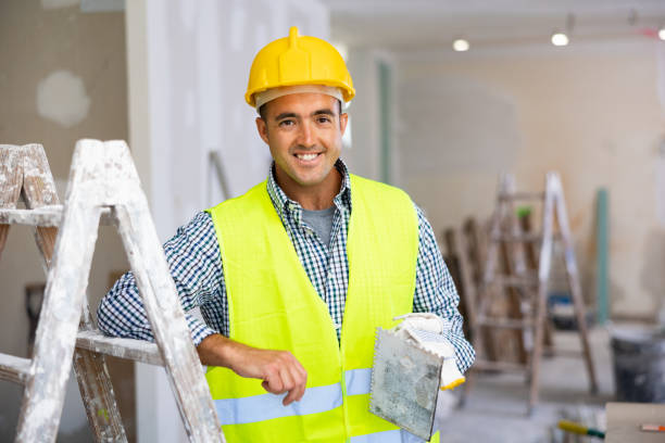 istock Portrait of positive man builder with float trowel 1408072875