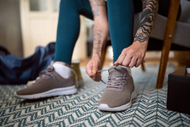 istock Unrecognizable Caucasian female athlete tying on shoelace 1408075893