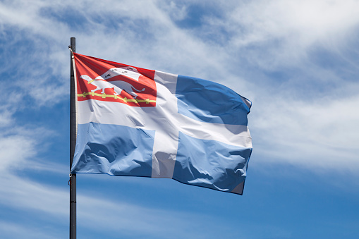 Flag of the city of Saint Malo waving un mid air.