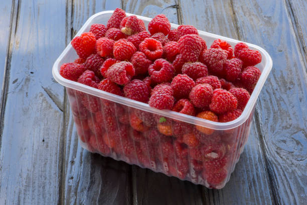 istock Trays with raspberries on a wooden background. 1408077169