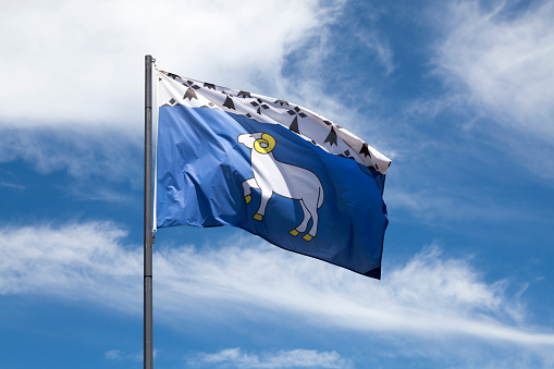 Flag of the city of Quimper waving un mid air.