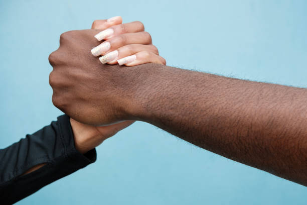 istock Man and woman shaking hands. Close up and blue background. 1408083329