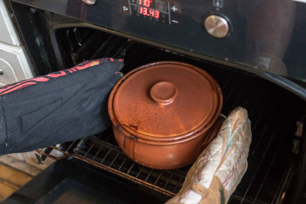 istock Taking casserole in clay pot out of oven 1408083421