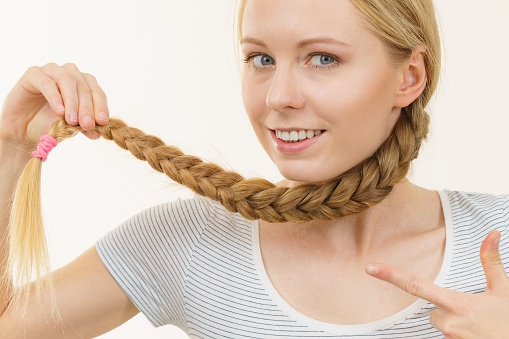 Blonde girl with long braid hair. Haircare, popular hairstyle.