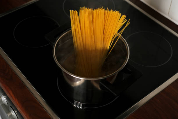 istock spaghetti in a pan on an induction stove close-up top view 1408091470