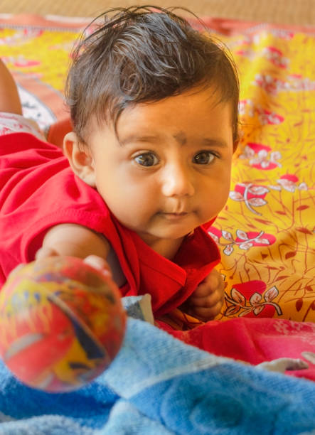 istock A cute Indian baby holding a ball towards camera 1408091957