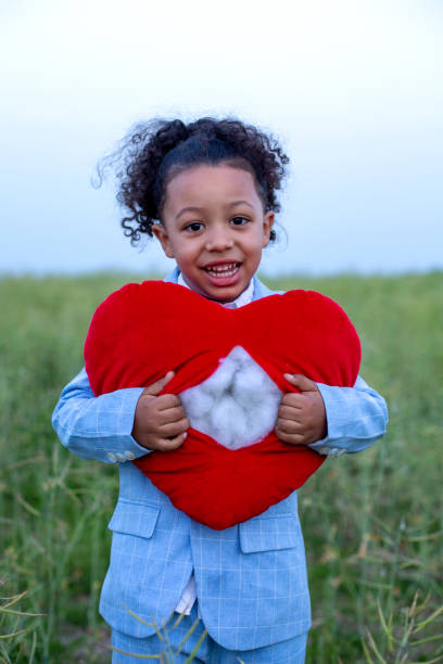 istock happy black boy standing outdoors and holding a ripped heart 1408093152