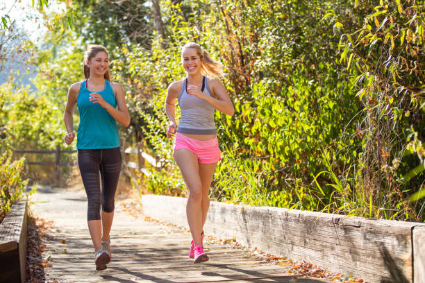 istock Female friends jogging outside together 1408093740