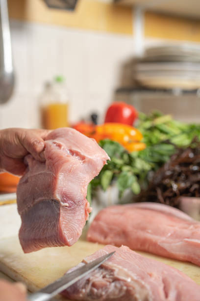 istock Cook holding piece of meat in a restaurant kitchen 1408097013
