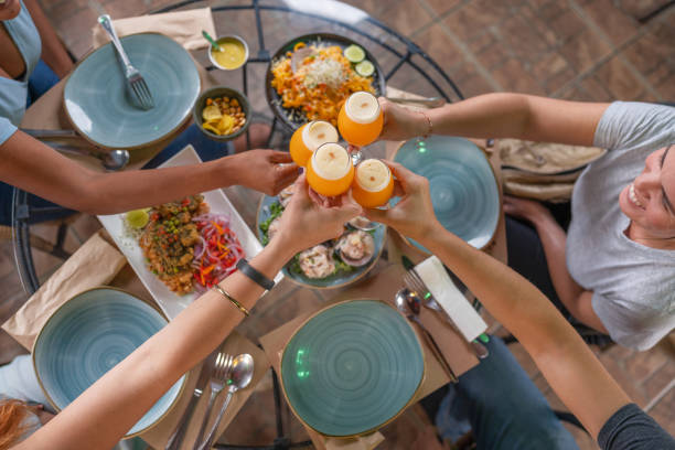 Group of people toasting with beer in a restaurant Top view of a group of people toasting with beer in a peruvian restaurant pub table top view stock pictures, royalty-free photos & images