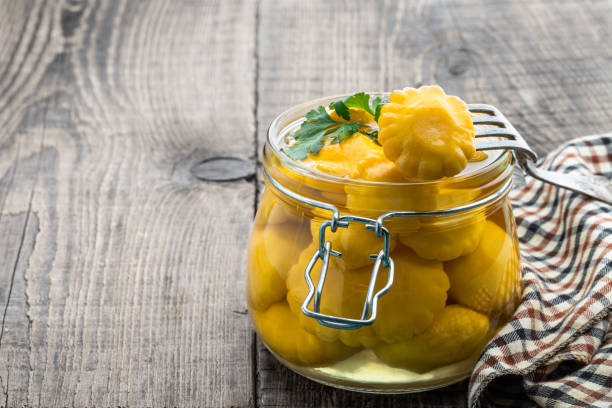 istock Marinated yellow squash in glass jar on wooden table 1408097829