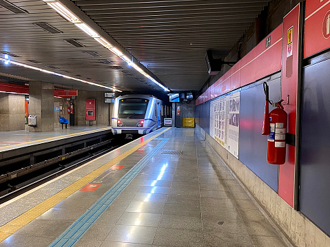 The subway station platform at T-Centralen in downtown Stockholm busy with passengers waiting as a train arrives in the station.