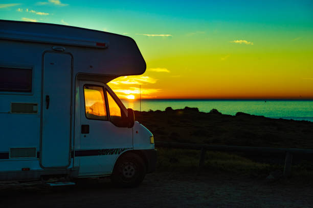 istock Camper vehicle on beach at sunrise 1408105148