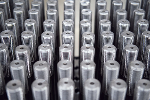 A lot of large metal bolts lined up in even rows