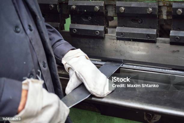 A Worker Bends A Plate With An Industrial Press Stock Photo - Download Image Now - Bending, Metal, Adult