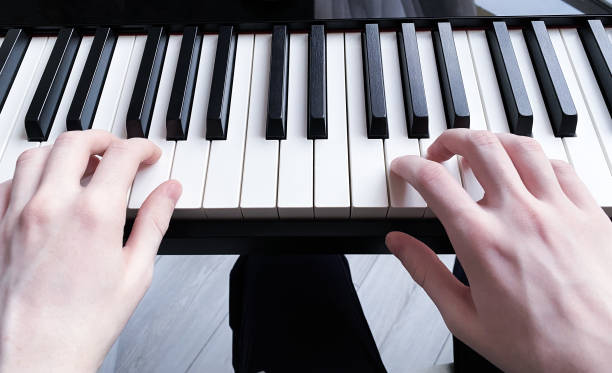 ピアノ楽器の鍵盤に若いピアニストの手 - piano keyboard instrument one person piano key ス��トックフォトと画像