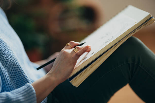 istock An Anonymous Woman Drawing Sketch In Her Notebook At Home 1408110281