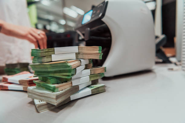 funcionários do banco usando máquina de contagem de dinheiro enquanto classificam e contam notas de papel dentro do cofre do banco. grandes quantidades de dinheiro no banco - moeda da bósnia herzegovina - fotografias e filmes do acervo