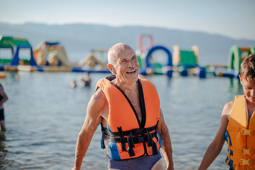 Senior man full with life spending time in Water Park with his grandson
