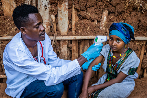 Doctor measuring body temperature with digital thermometer, East Africa