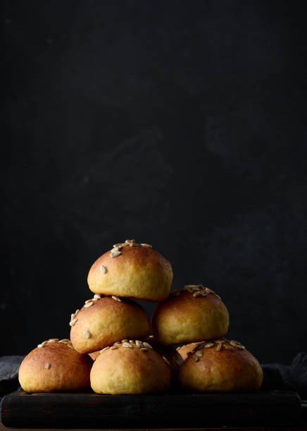 istock Baked round buns on a wooden table, black background 1408120800