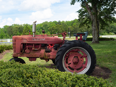An old farm tractor sits by the side of the road