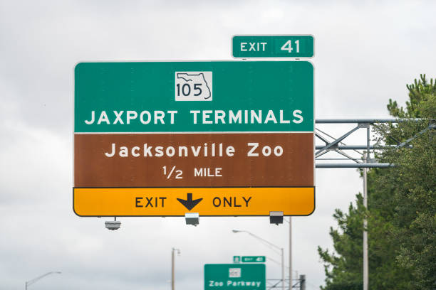 jacksonville, ee.uu. autopista interestatal i295 carretera en florida y señales de direcciones para las terminales de la autoridad portuaria de jaxport y la salida del zoológico sólo carril en la calle us 105 - river road sign road sign fotografías e imágenes de stock