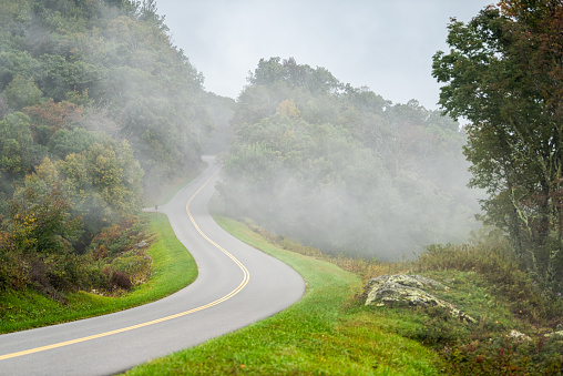 Blue Ridge Parkway road, North Carolina fall foliage mountains national park forest with fog moody weather and nobody in beautiful landscape