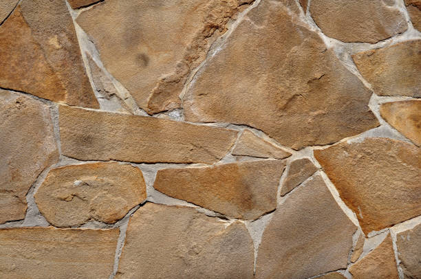 istock Yellow stone limestone texture, irregular shape and natural lines. Retaining wall 1408127857