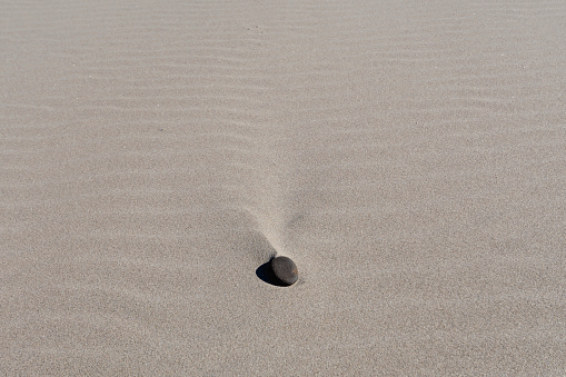 One rock on a sandy beach