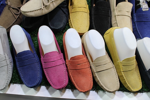 Colorful selection of suede loafers for sale in market