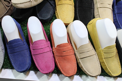 Colorful selection of suede loafers for sale in market