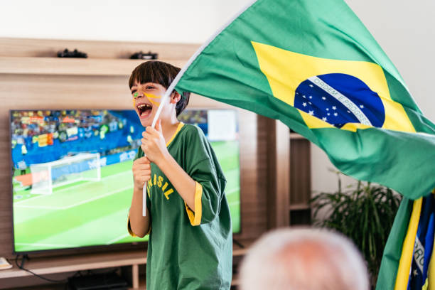 Boy celebrating a goal in Brazil in the living room stock photo